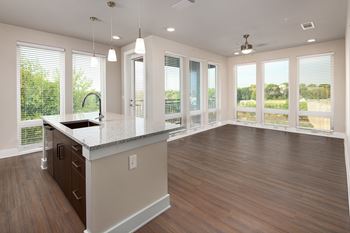 A kitchen with a large island and floor to ceiling windows